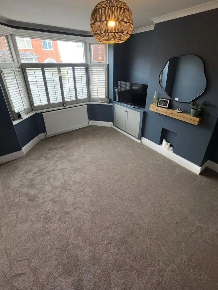 New carpet in a room with a bay window and blue walls